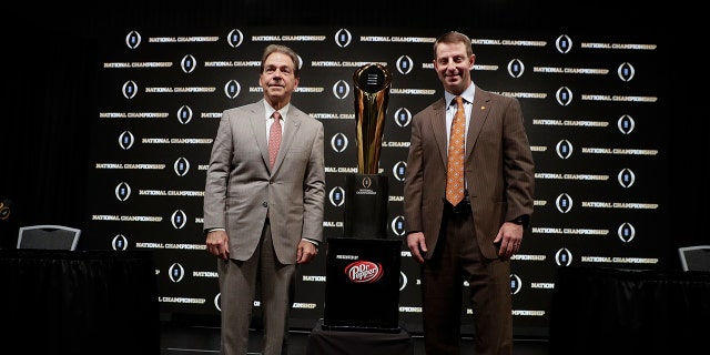Alabama head coach Nick Saban and Clemson head coach Dabo Swinney pose with the trophy at a news conference for the NCAA college football playoff championship game Sunday, Jan. 6, 2019, in Santa Clara, Calif.