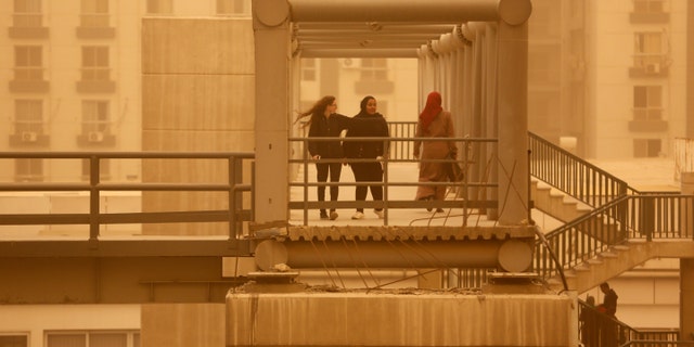 Pedestrians cross a bridge during a sandstorm in Cairo, Egypt, Wednesday, Jan. 16, 2019 as a thick sandstorm cloaked parts of the Middle East.