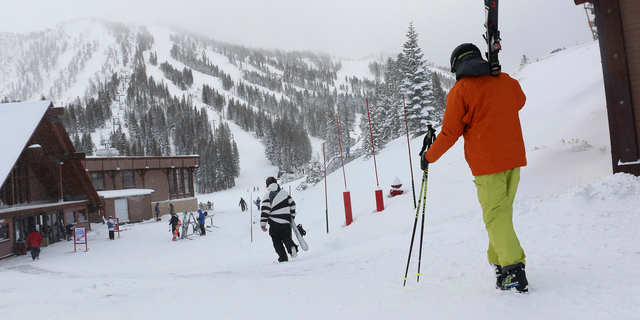 FILE - In this Nov. 29, 2018, file photo, skiers and snowboarders walk to the lifts at Mt. Rose Ski Tahoe near Reno, Nev.