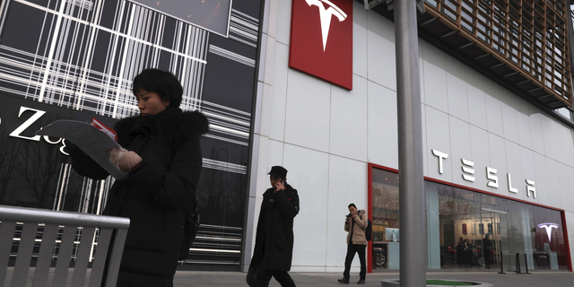Residents walk past a Tesla store in Beijing, China, Monday, Jan. 7, 2019. Tesla Motors CEO Elon Musk said Monday on twitter that the automaker is breaking ground for a Shanghai factory and will start production of its Model 3 by the end of the year. (AP Photo/Ng Han Guan)