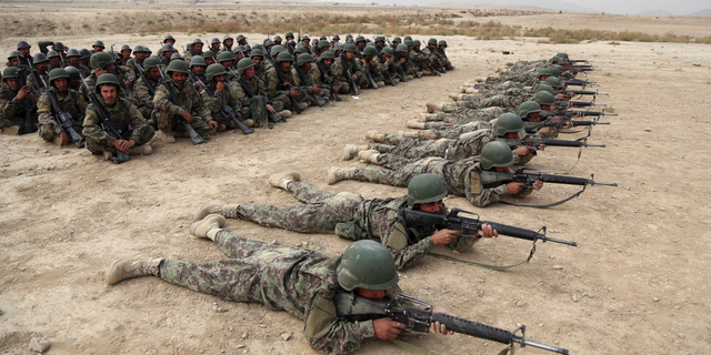 In this Oct. 31, 2018, photo, Afghan National Army (ANA) soldiers carry out an exercise during a live firing at the Afghan Military Academy in Kabul, Afghanistan.