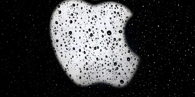 FILE- In this Dec. 26, 2018, file photo an Apple logo is seen in raindrops on a window outside an Apple Store at the Country Club Plaza shopping district in Kansas City, Mo. (AP Photo/Charlie Riedel, File)