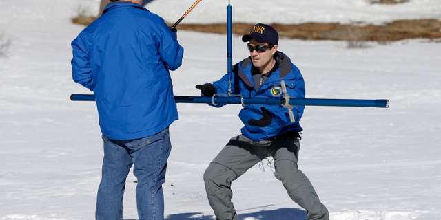 Department of Water Resources Water Resource Engineer John King, right, places the snow survey tube to on a scale held by DWR State Climatologist Dr. Michael Anderson, left , during the first snow survey of the season at Phillips Station, Thursday, Jan. 3, 2019, near Echo Summit, Calif. California water managers said Thursday the Sierra snowpack is only 67 percent of normal in this winter's first manual measurement. Winter snow in the Sierra provides drinking water for much of California as it melts in the spring and summer and flows into reservoirs for storage. (AP Photo/Rich Pedroncelli)