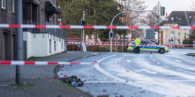 The Police blocks a road in Bottrop, Germany, Tuesday, Jan. 1, 2019. A man has been arrested in Germany after ploughing his car into a crowd of people, injuring at least four, in what appears to have been an intentional attack directed at foreigners, police said Tuesday. (Marcel Kusch/dpa via AP)