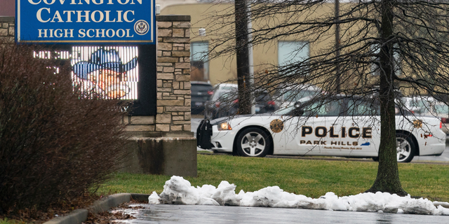 A police car sits at the entrance to Covington Catholic High School in Park Hills, Ky., Saturday, Jan 19, 2019. A diocese in Kentucky apologized Saturday after videos emerged showing students from the Catholic boys' high school mocking Native Americans outside the Lincoln Memorial on Friday after a rally in Washington. (AP Photo/Bryan Woolston)