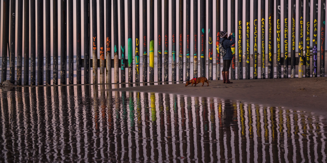 FILE - In this Jan. 3 photo, a woman at the border fence between San Diego and Tijuana, as seen from Mexico. The top House Republican says a bipartisan border security compromise that Congress hopes to produce doesn't have to include the word "wall." (AP Photo/Daniel Ochoa de Olza, File)
