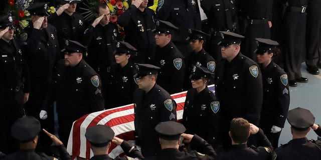 Davis Police officers salute the flag-draped coffin of Davis Police Officer Natalie Corona after funeral services for Corona at the University of California, Davis, Friday, Jan. 18, 2019, in Davis, Calif. (Associated Press)