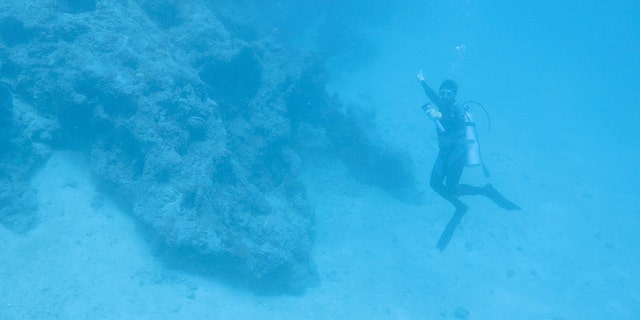 A diver points toward the aircraft discovered off Buka Island, Papua New Guinea.