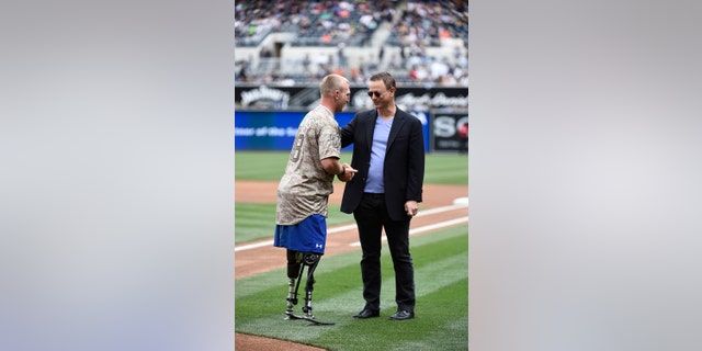 Veteran Rob Jones talks with actor Gary Sinise after throwing out the first pitch during Military Opening Day before an inter-league baseball game between the Detroit Tigers and the San Diego Padres at Petco Park April 13, 2014 in San Diego, California.