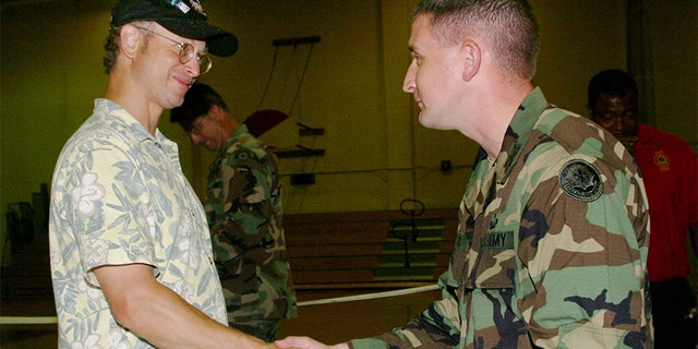 Actor Gary Sinise shakes the hand of Army Capt. Marc Melton at Fort Polk Army Post on June 24, 2004, in Fort Polk, Louisiana. Sinise, an Academy Award-nominated actor, stopped at the Central Louisiana post on the first day of a 10-day USO tour of military installations in the U.S. Sinise performed with his touring band, "The Lt. Dan Band." 