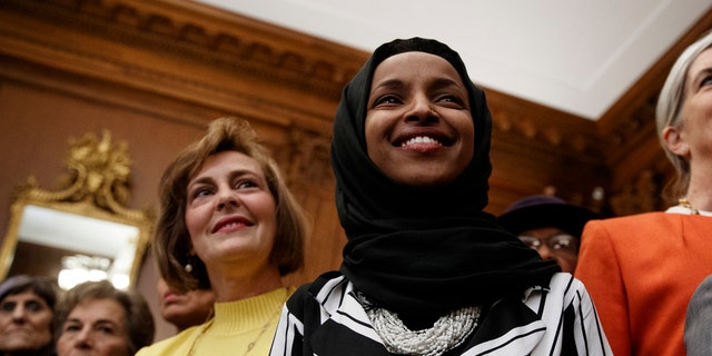 Rep. Ilhan Omar, D-Minn., center, joins other Democrats during a news conference on Capitol Hill in Washington, Friday, Jan. 4, 2019, about the introduction of H.R. 1 - For the People Act. (AP Photo/Carolyn Kaster)