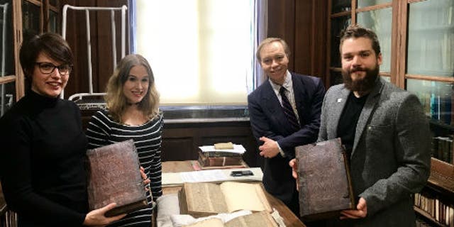 Left to right: Leah Tether, Laura Chuhan Campbell, Michael Richardson and Benjamin Pohl with the books in Bristol Central Library’s Rare Books Room