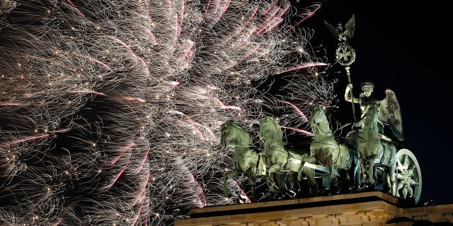 Fireworks light the sky above the Quadriga at the Brandenburg Gate shortly after midnight in Berlin, Germany, Tuesday, Jan. 1, 2019. Hundred thousands of people celebrated New Year's Eve welcoming the new year 2019 in Germany's capital. (AP Photo/Michael Sohn)