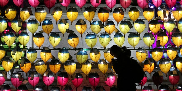 A woman prays in front of a wall of lanterns to celebrate the New Year at the Jogyesa Buddhist temple in Seoul, South Korea, Monday, Dec. 31, 2018. (AP Photo/Ahn Young-joon)