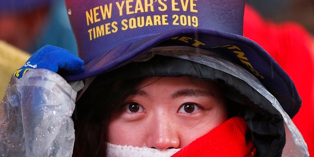 A reveler adjusts her hat as she waits in Times Square in New York on Monday, Dec. 31, 2018, while taking part in a New Year's Eve celebration. (AP Photo/Adam Hunger)