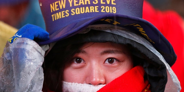 A reveler adjusts her hat as she waits in Times Square in New York on Monday, Dec. 31, 2018, while taking part in a New Year's Eve celebration. (AP Photo/Adam Hunger)