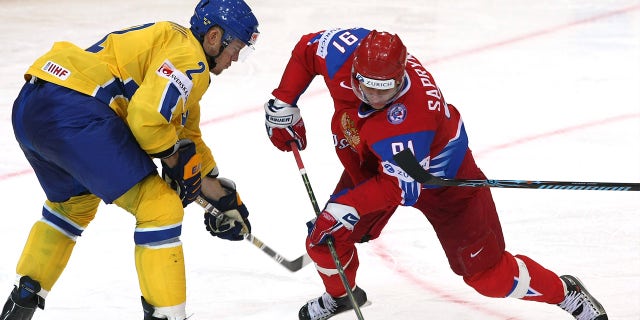 Oleg Saprykin (R) of Russia fights for the puck with Nicklas Grossman (L) of Sweden during the IIHF World Ice Hockey Championship qualification round match between Russia and Sweden on April 30, 2009.