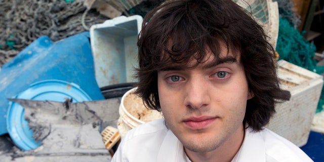 FILE - In this May 11, 2017, file photo, Dutch innovator Boyan Slat poses for a portrait next to a pile of plastic garbage prior to a press conference in Utrecht, Netherlands. (AP Photo/Peter Dejong, File)