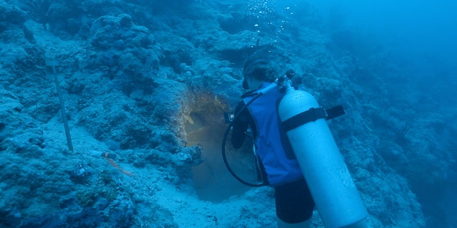 Filmmaker Stephani Gordon records the encrusted cockpit area of the aircraft discovered off the coast of Buka Island. (Stephani Gordon, Open Boat Films)