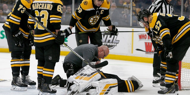 Boston Bruins goaltender Tuukka Rask (40) is attended to by medical personnel as his teammates look on after taking a hit on a goal by New York Rangers center Filip Chytil during the first period of an NHL hockey game, Saturday, Jan. 19, 2019, in Boston. (Associated Press)