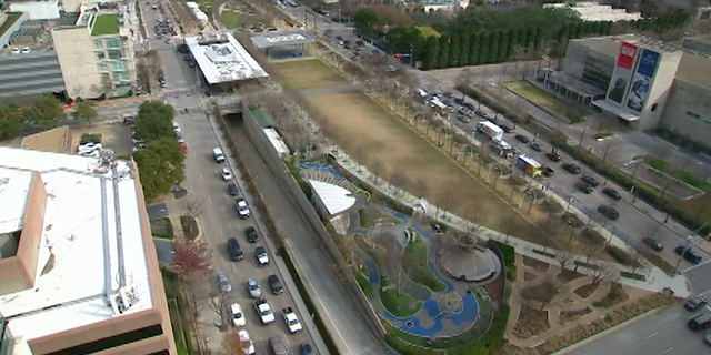 Cars pass under and beside Dallas' Klyde Warren Park.