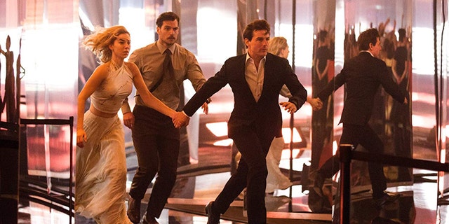 (L-R): Vanessa Kirby, Henry Cavill, and Tom Cruise run from danger in 'Fallout.'