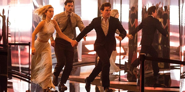(L-R): Vanessa Kirby, Henry Cavill, and Tom Cruise run from danger in 'Fallout.'