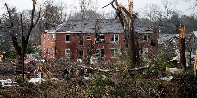 Resue workers make their way to a damaged apartment building after a tornado touchdown in Wetumpka, Ala., on Saturday, Jan. 19, 2019.