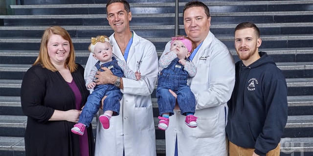 The twins, now over 2 years old and pictured here with their surgeons and parents, have started babbling and are involved in physical, developmental and speech therapies.