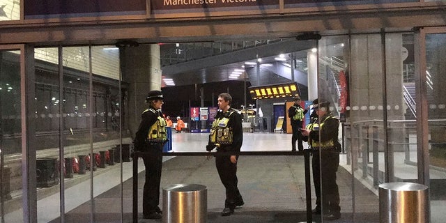 Police at Victoria Station in Manchester, England, late Monday Dec. 31, 2018 after a man had stabbed three people.