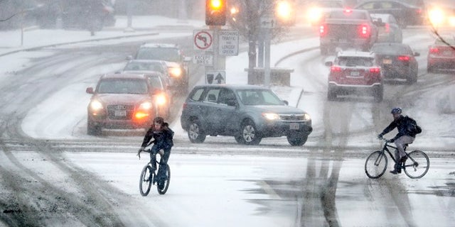 Bikers crossing Park Street at the intersection of University Ave during a late afternoon snow storm Friday, Jan. 18, 2019 in Madison, Wis.