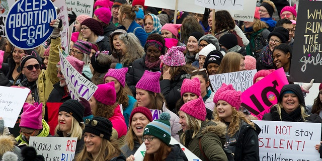 Demonstrators hold up their banners as they march on Pennsylvania Avenue during the Women's March in Washington on Saturday, Jan. 19, 2019. (AP Photo/Jose Luis Magana)