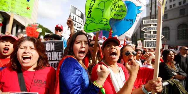 Elementary school teachers Iris Marin, second from left, center, and Mireya Gutierrez, right, and Lorena Redford, rally in downtown Los Angeles, Friday, Jan. 18, 2019.