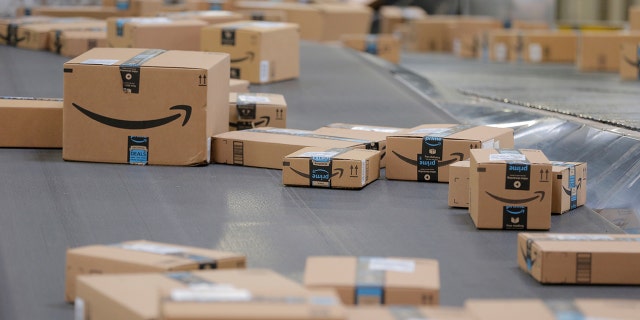 Packages emblazoned with Amazon logos travel along a conveyor belt inside of an Amazon fulfillment center. (Reuters)