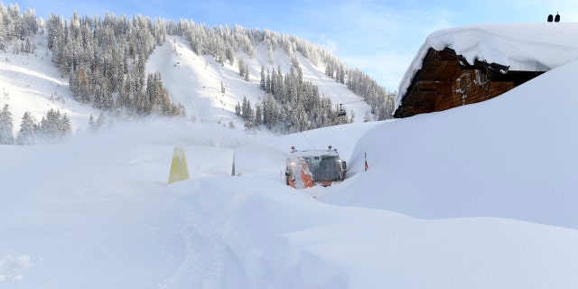 A snow blower works on a road at the Loferer Alp, Austrian province of Salzburg, Friday, Jan. 11, 2019.