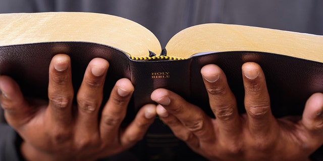 A close up view of a man hands holding the Holy Bible, Worship Concept