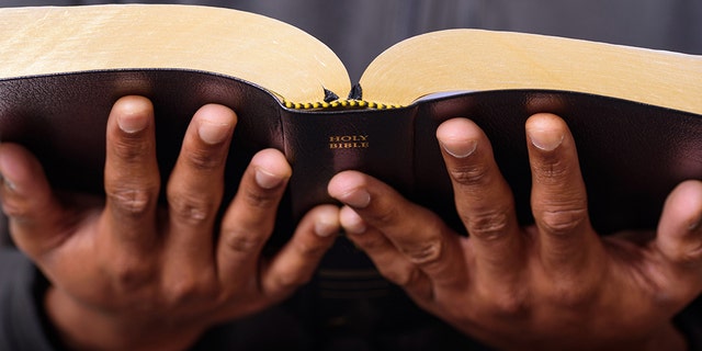 A close up view of a man hands holding the Holy Bible, Worship Concept