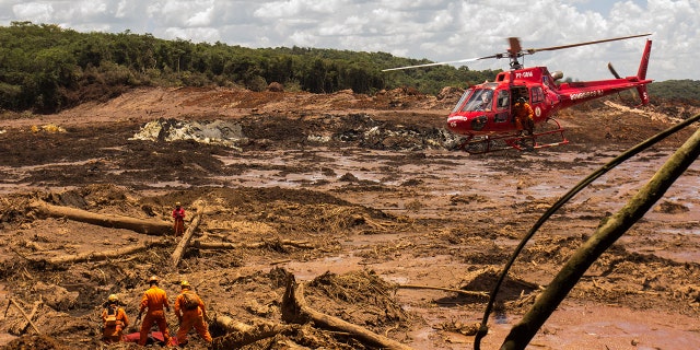 On Tuesday in Brumadinho, firefighters recover a body with a chopper's assistance. (Photo by Rodney Costa/picture alliance via Getty Images)