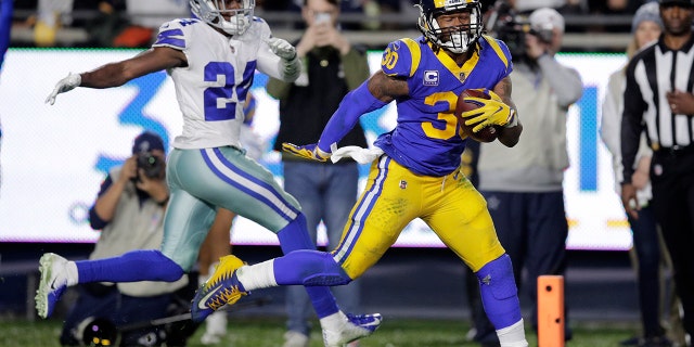 Los Angeles Rams running back Todd Gurley scores past Dallas Cowboys cornerback Chidobe Awuzie during the first half in an NFL divisional football playoff game Saturday, Jan. 12, 2019, in Los Angeles. (Associated Press)