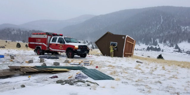 A woman and two cats were inside the tiny house when it was blown away by fierce winds, according to fire officials.