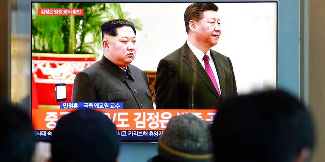 People watch a TV screen showing file footage of North Korean leader Kim Jong Un and Chinese President Xi Jinping, right, during a news program at the Seoul Railway Station in Seoul, South Korea.