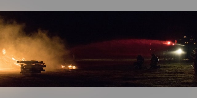 Massachusetts National Guard soldiers with the 79th Engineer Company (Firefighting) hose down a car fire during a training exercise at Tactical Training Base Kelly, Joint Base Cape Cod, Massachusetts on June 9th, 2018.