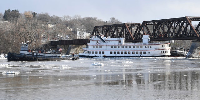 Crews from the tugboats Frances, left, and Margot work to free the Captain J.P. III cruise ship that broke away from its winter moorings in Troy, N.Y., and floated down river.