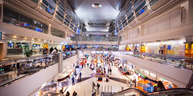 Night shot of modern duty free area in transit of new terminal for A 380 in airport Dubai. People are walking on both levels.