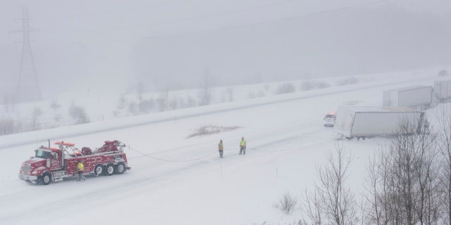 A Merl's Towing Service truck pulls a semi-trailer truck out of the snow along M-6 near exit 1 near Grandville on Wednesday, Jan. 30, 2019. Subzero temperatures were recorded across the area.