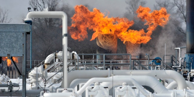Fire comes out of the top of two silo-looking structures at the compressor station at Consumers Energy in Armada Township, Mich. Consumers Energy has called on customers to voluntarily reduce their natural gas usage following a fire at a suburban Detroit gas compressor station amid bitterly cold weather.