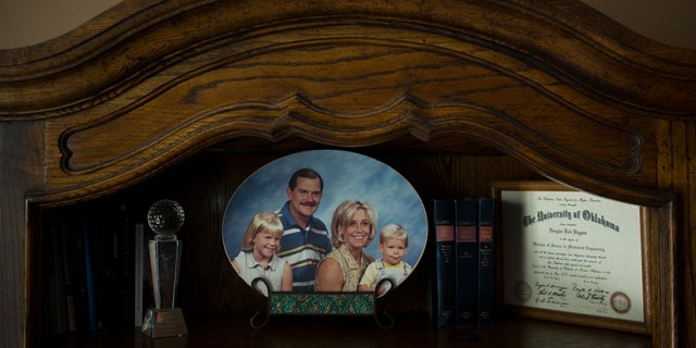 Landon Biggers sits on his mother’s lap in an old family photo in his father’s home office in La Quinta, Calif.