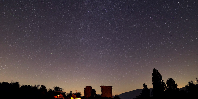 Several Perseid meteors dash across the sky above Italy's Castel Santa Maria in this photo by astrophysicist Gianluca Masi of the Virtual Telescope Project taken during the peak on Aug. 12-13, 2018.