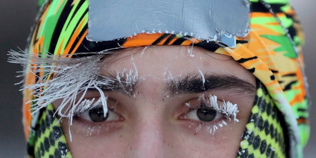 Frost covers part of the face of University of Minnesota student Daniel Dylla during a morning jog along Mississippi River Parkway Tuesday, Jan. 29, 2019, in Minneapolis.