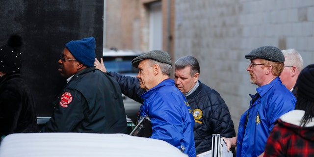 FILE - In this Jan. 16, 2019 file photo, City inspectors from the Department of Buildings and the Chicago Fire Department enter from the back door alley entrance to the studio space for musician R. Kelly in Chicago. A judge says a Chicago warehouse that R. Kelly is renting can be used only between 9 a.m. and 5 p.m. and only as a recording studio. The Chicago Sun-Times says the Cook County judge also prohibited use of the second floor Tuesday, Jan. 22, 2019, after building inspectors found faulty stairs.